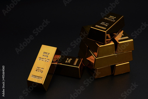 A pile of gold bar a black background. Shiny precious metals for investments or reserves. photo