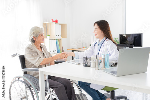 Asian doctor talk with old female patient about disease symptom, they holding hand together, elderly health check up, happiness hospital, hand in hand