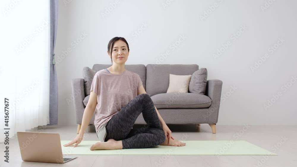 パソコンを見てストレッチをする女性 パソコンを見てストレッチをする女性