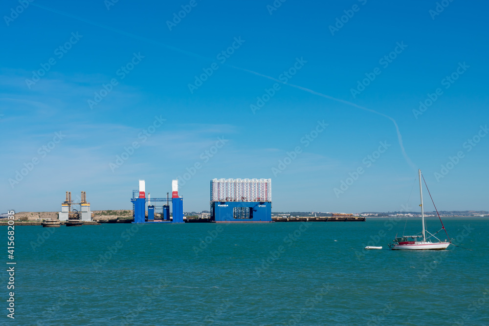 Obraz premium Cranes to repair boats in the bay of Cadiz capital, Andalusia. Spain. Europe. February 14, 2021