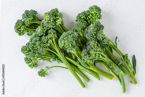 Organic raw broccolini on a white cutting board, ready for roasting
 photo