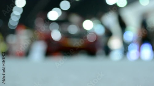 Defocused of ground level video clip of anonymous people walking in bokeh light