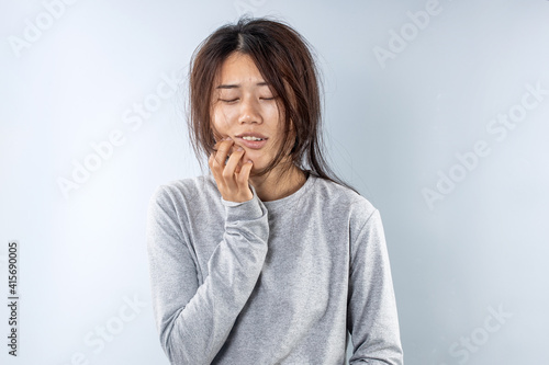 A woman in Asia is suffering from a toothache