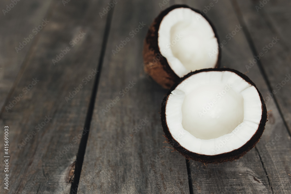 Broken coconuts on gray wooden background. White coconut pulp Broken coconuts on gray wooden background. White coconut pulp