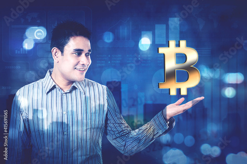 Double exposure of young man showing bitcoin symbol