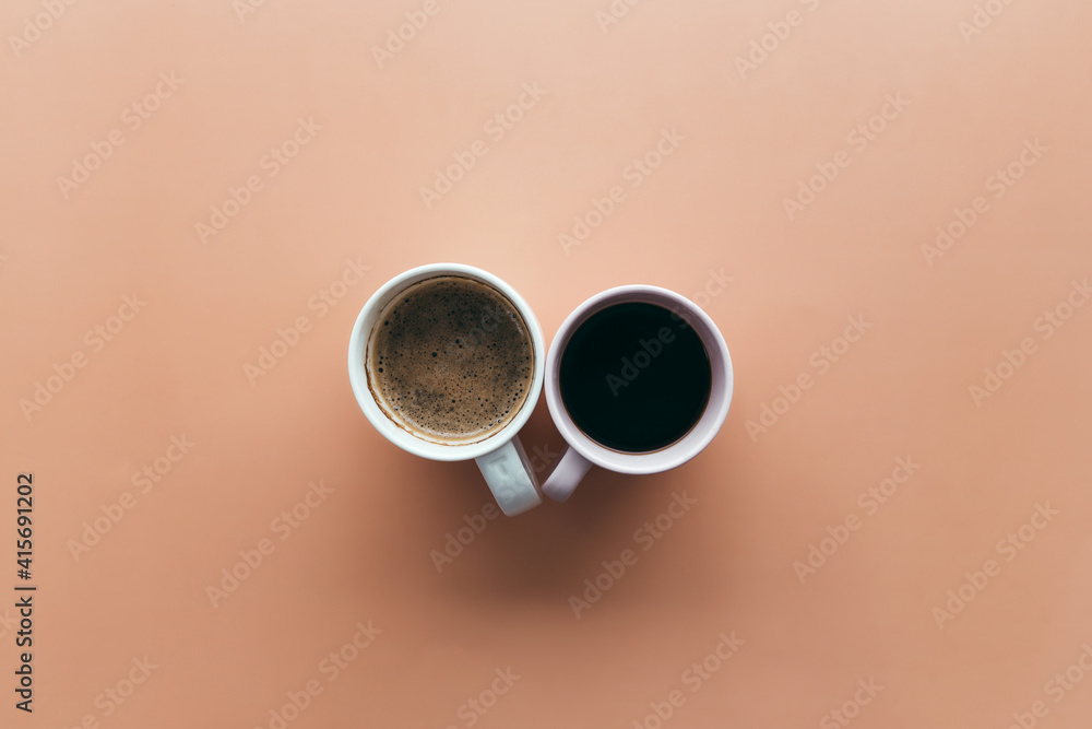 Two pink and blue coffee cups on beige background Two pink and blue coffee cups on beige background