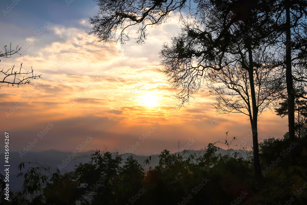 The landscape of natural mountains and hill with sunrise, trees are silhouette The landscape of natural mountains and hill with sunrise, trees are silhouette