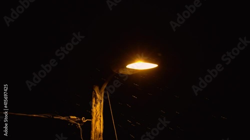 Closeup of a warm glowing lamp-post during a snowstorm photo