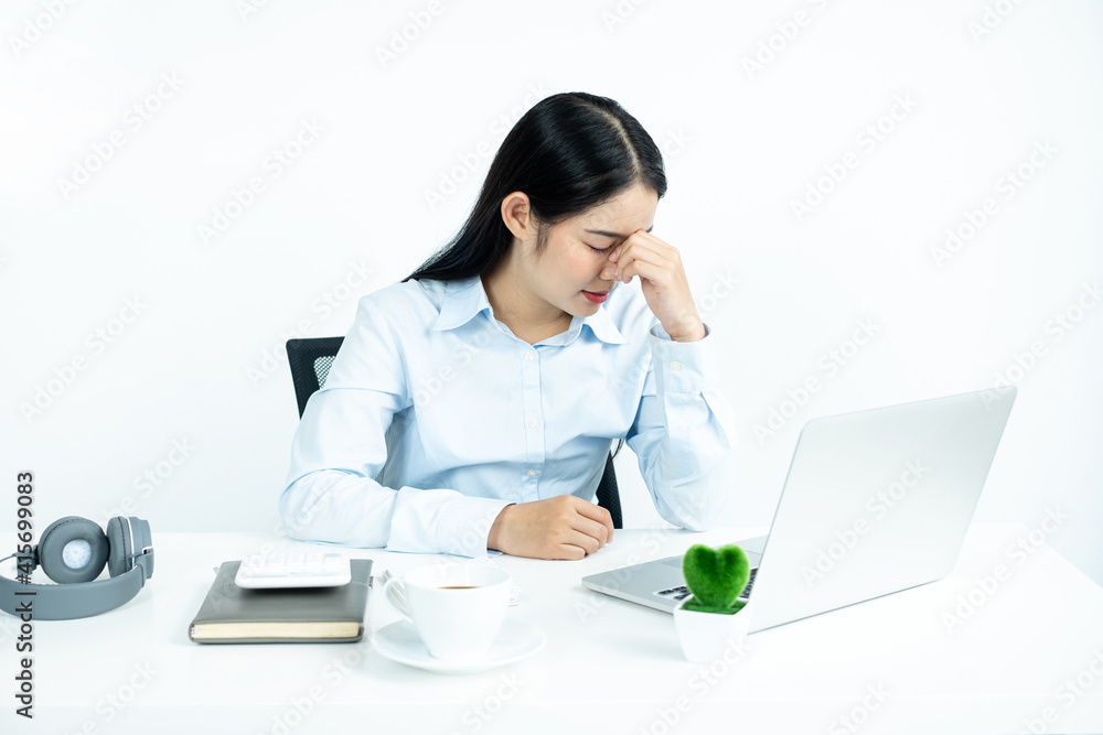 Working Asian women feel stressed, tired from work, migraine headaches from hard work while working at the office Working Asian women feel stressed, tired from work, migraine headaches from hard work while working at the office