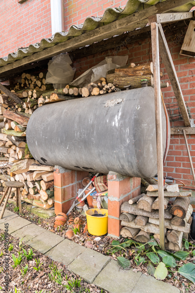 In addition to the facade, there is a fuel oil tank and piles of wood In addition to the facade, there is a fuel oil tank and piles of wood