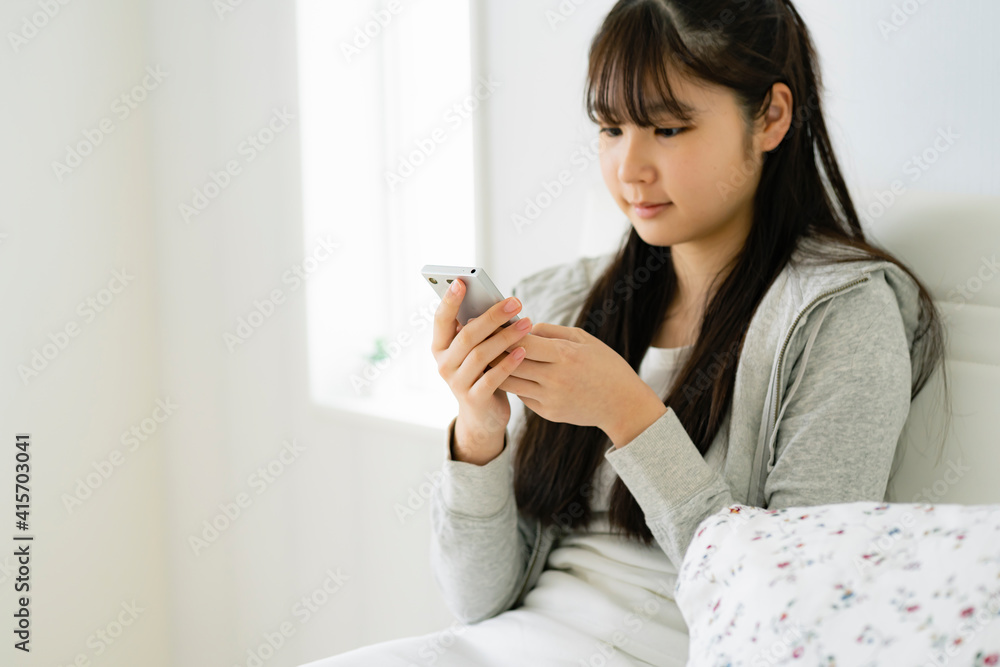 スマートフォンを見る日本人の女の子 スマートフォンを見る日本人の女の子