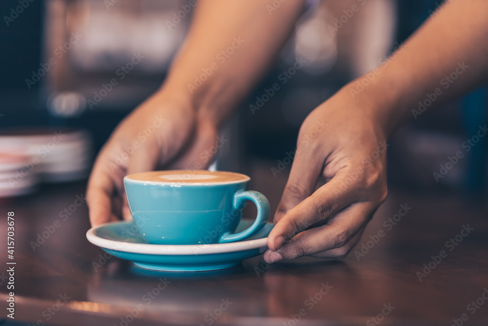 Barista serving a coffee to customer at the coffee shop. Barista serving a coffee to customer at the coffee shop.