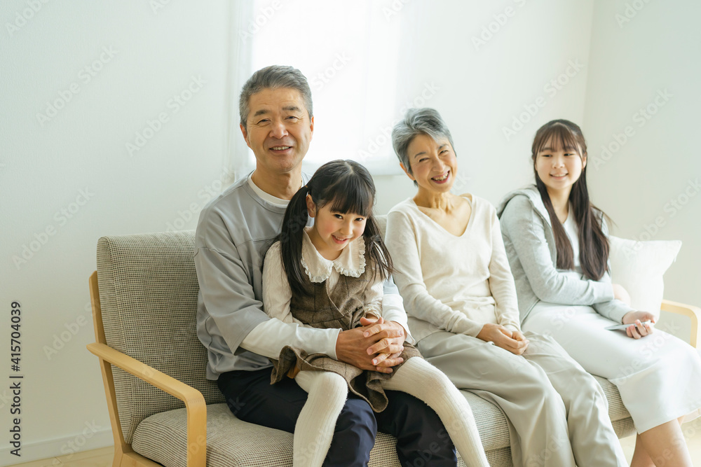 ソファに座りくつろぐシニア夫婦と孫 ソファに座りくつろぐシニア夫婦と孫