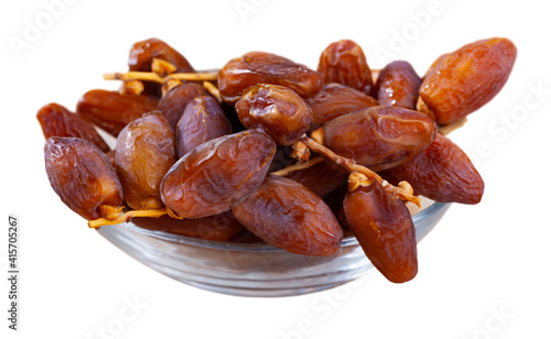 Pile of sweet dried dates in plate. Popular product for boosting immunity. Isolated over white background