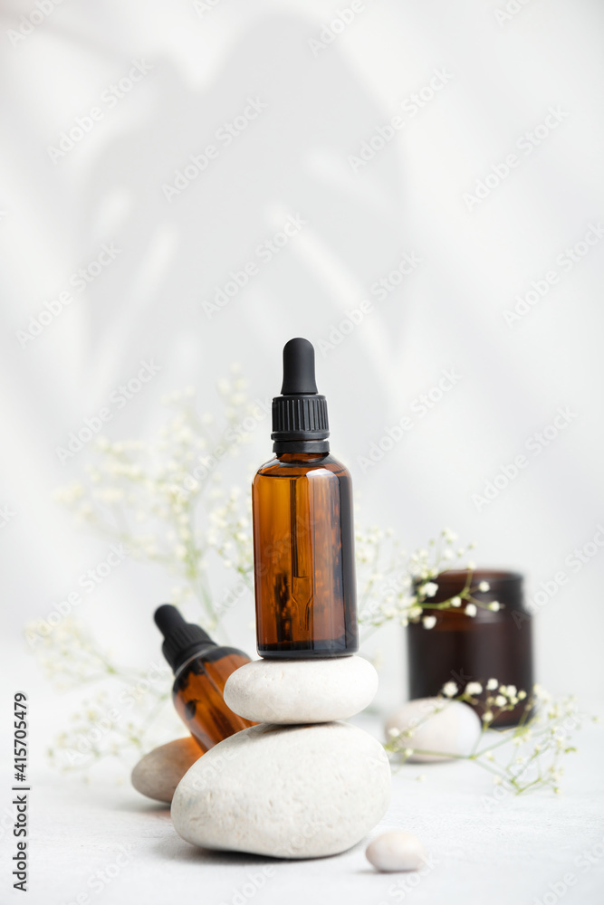 Bottle of dark amber glass with essential oil on stack of natural stones, copy space Bottle of dark amber glass with essential oil on stack of natural stones, copy space