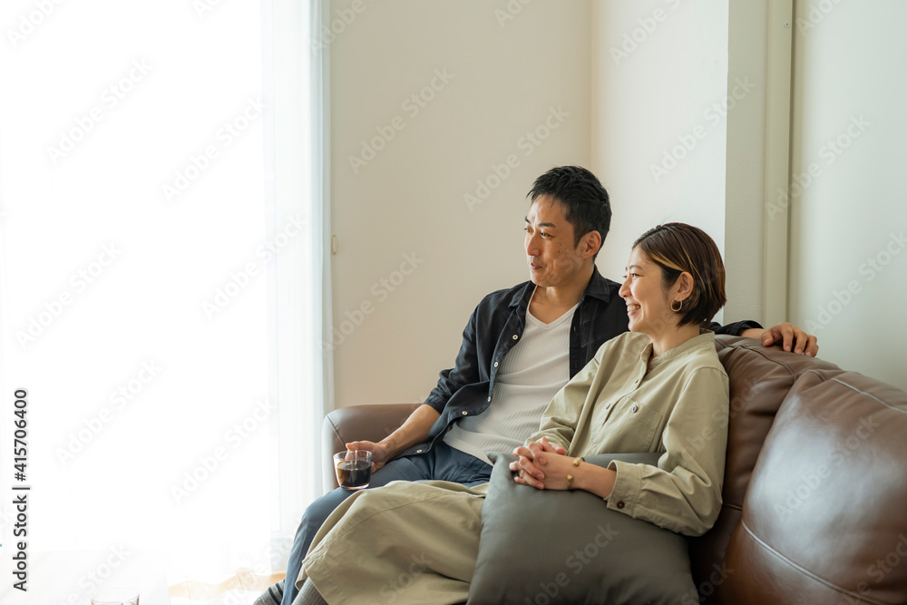ソファに座りくつろぐ日本人夫婦 ソファに座りくつろぐ日本人夫婦
