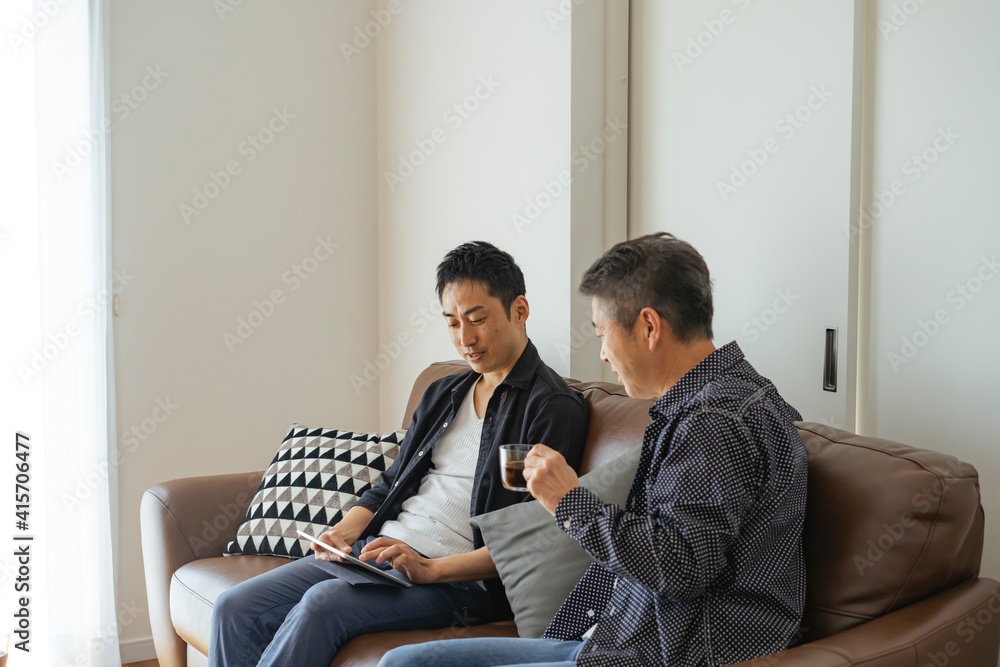 ソファに座りくつろぐ日本人シニア男性と息子 ソファに座りくつろぐ日本人シニア男性と息子