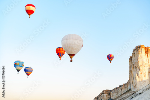 Colorful air balloons flying in clear sky near huge white mountain © fotofabrika