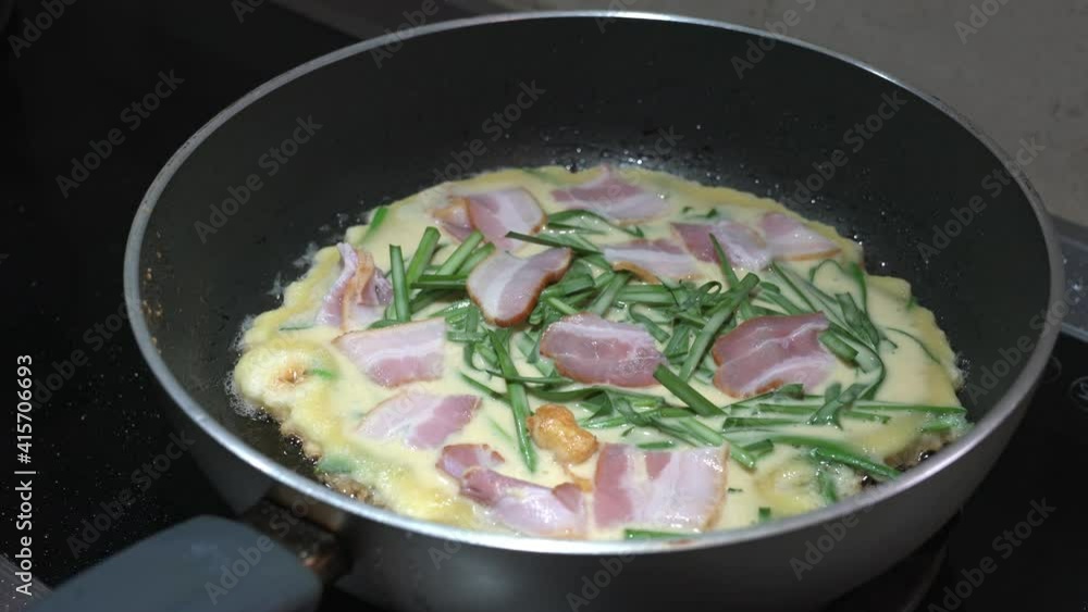 Korean pancake, with mixture of vegetables and meat, on a frying pan. Home cooking concept. Korean pancake, with mixture of vegetables and meat, on a frying pan. Home cooking concept.