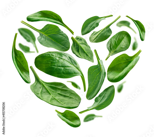 Green spinach leaves in the shape of a heart on a white background photo