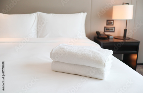 Clean white bath towels on the neatly clean bed with - coziness and clean concept