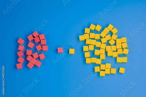 Two groups of wooden blocks on blue background. Team, leadership, competition and negotiation concept