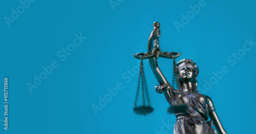 Justitia Statue vor blauem Hintergrund. Symbol für Recht und Anwalt.