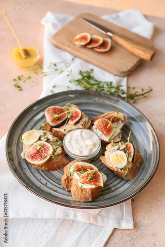 Tasty sandwiches with fig on color background