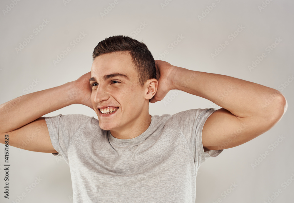 cheerful man gesturing with his hands in a white t-shirt light background cropped view cheerful man gesturing with his hands in a white t-shirt light background cropped view