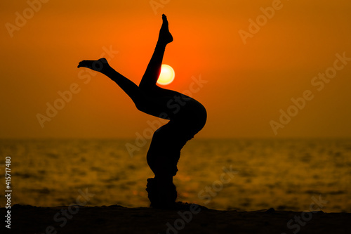 Silhouette sport woman pose practice yoga exercise on sand beach in morning   yoga is meditation heathy sport concept.