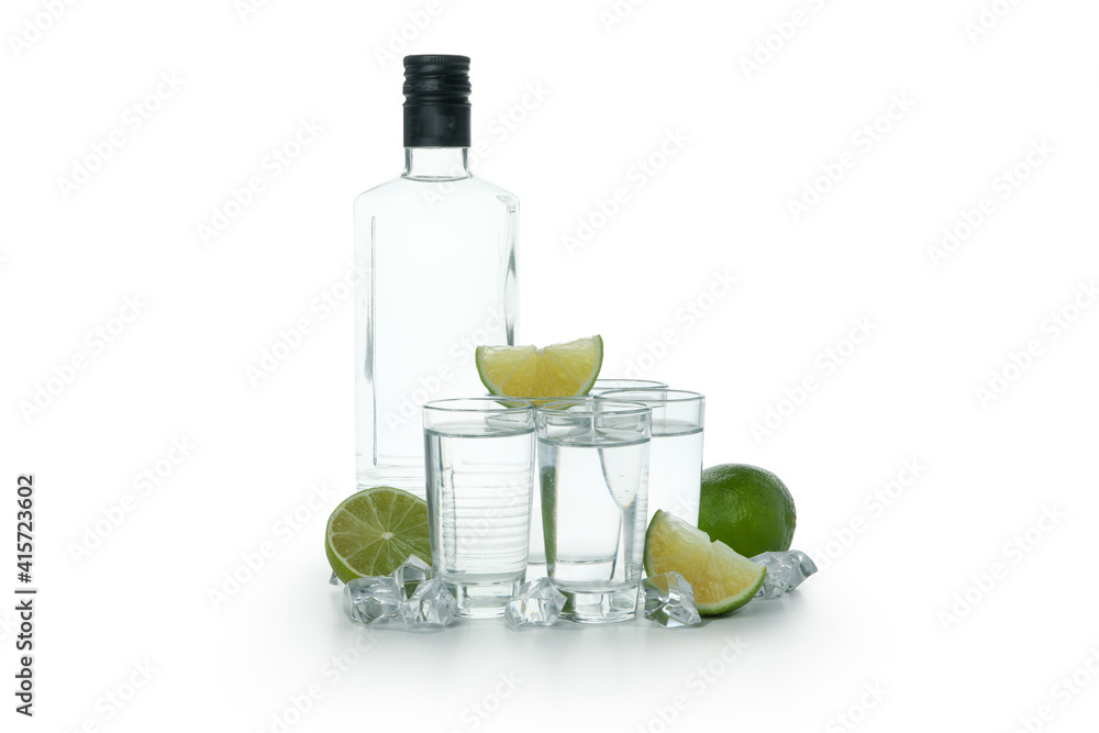 Bottle of vodka, shots, ice cubes and lime slices isolated on white background Bottle of vodka, shots, ice cubes and lime slices isolated on white background