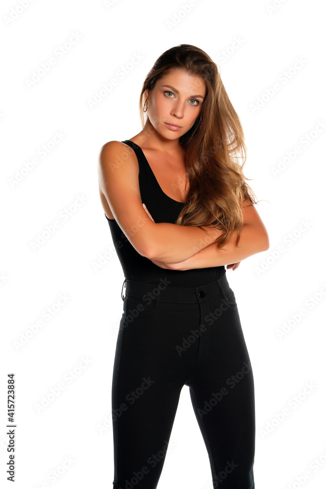 a young beautiful serious woman in pants and a shirt with crossed hands a young beautiful serious woman in pants and a shirt with crossed hands