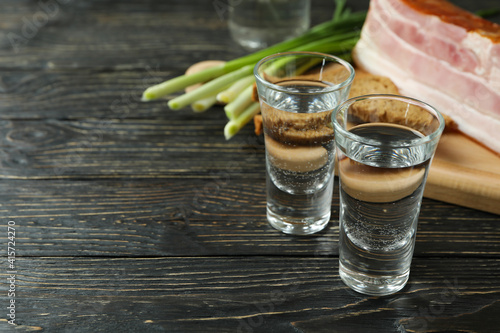 Vodka, onion, bacon and bread on wooden background