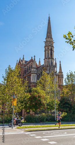 Sunny church on a tree-lined street in the city of Barcelona