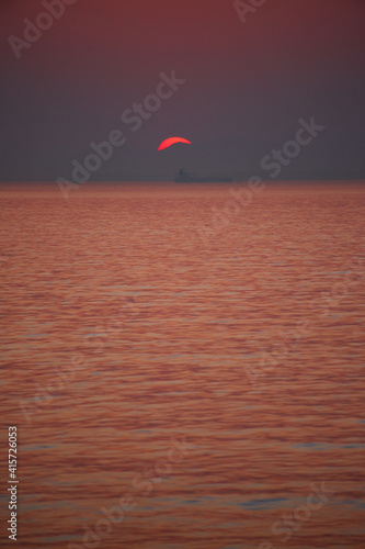 伊勢湾の鮮やかな夕焼けと海の日の入りの風景と海面の船の姿 © zheng qiang