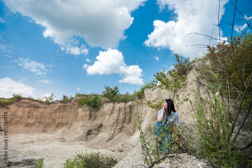 portrait of pretty young woman at nature. summer trip to sand quarry