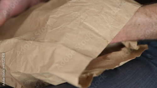 A man is pulling out of a paper bag US dollars.