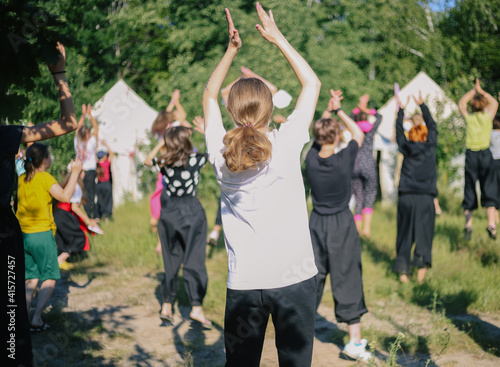 Group of children jumping doing morning exercises yoga-sport outdoors in nature in a children's summer camp