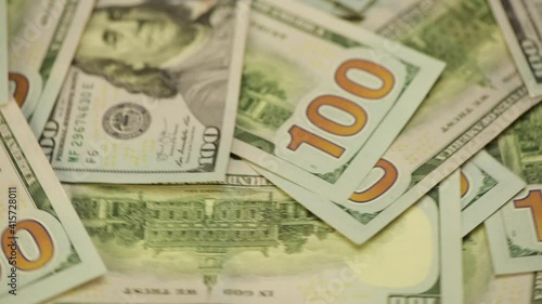 One hundred US dollar banknotes are circling.