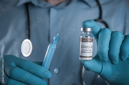 Doctor with a stethoscope on shoulder holding in hand COVID-19 , coronavirus, SARS-cov-2 vaccine. Healthcare And Medical concept.Development and creation vaccine