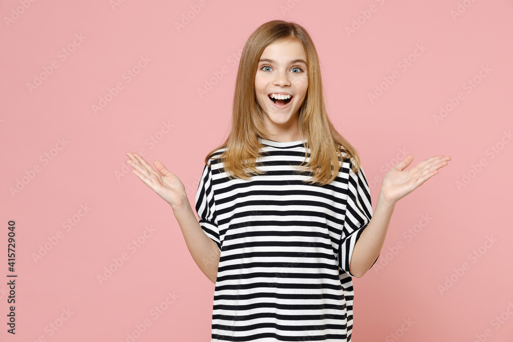 Little blonde cute nice smiling cute kid girl 12-13 years old wearing striped oversized t-shirt spread hands isolated on pastel pink background children studio portrait. Childhood lifestyle concept. Little blonde cute nice smiling cute kid girl 12-13 years old wearing striped oversized t-shirt spread hands isolated on pastel pink background children studio portrait. Childhood lifestyle concept.