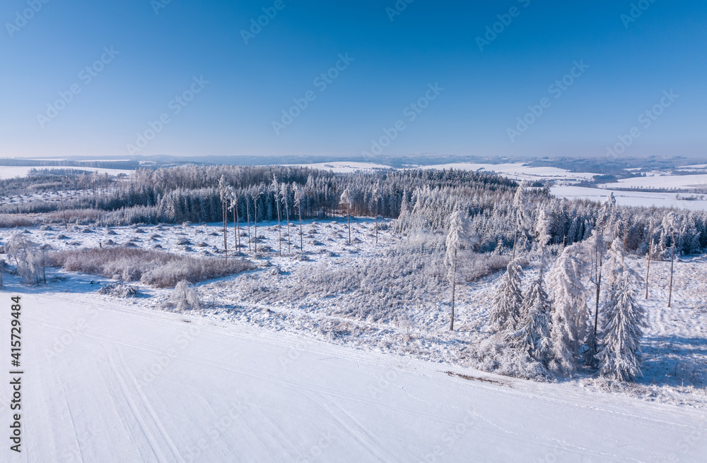 Aerial view of partially deforested landscape with creek, winter theme. Czech Republic, Vysocina region highland