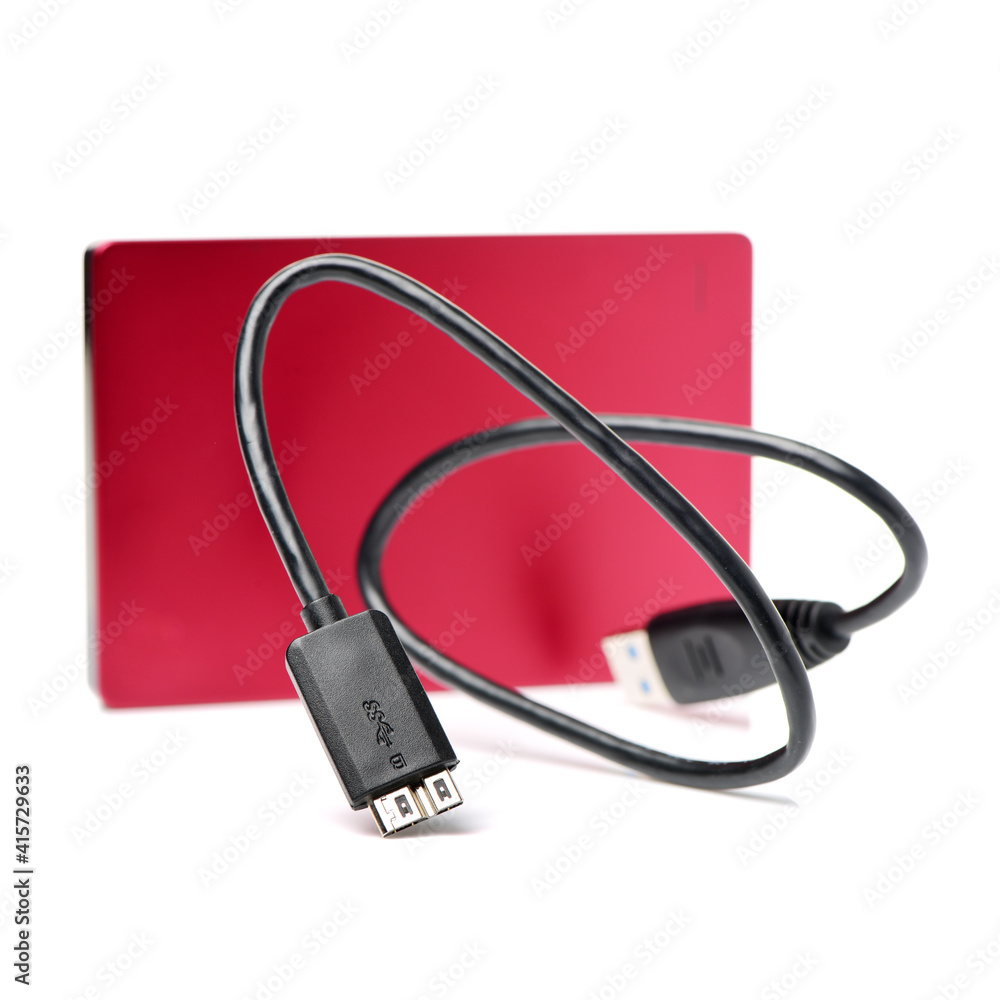 Red external hard drive with usb cable on the white background Red external hard drive with usb cable on the white background