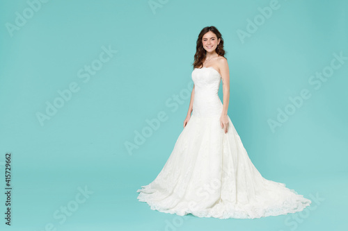 Quadro su tela Full length of charming pretty bride young woman 20s in beautiful white wedding dress looking camera isolated on blue turquoise color background studio portrait