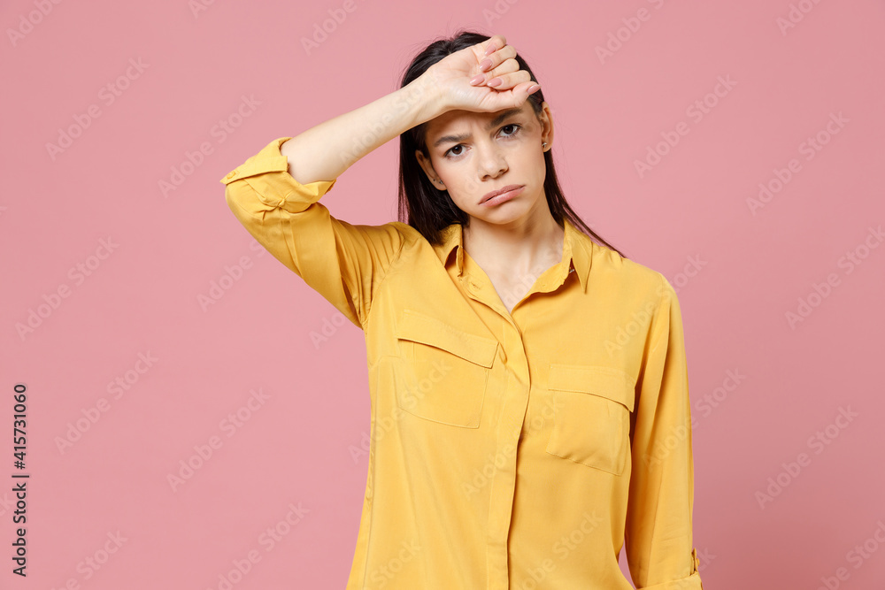 Young brunette tired exhausted pensive overthinking latin sick ill woman 20s wearing yellow casual shirt proping up forehead head looking camera isolated on pastel pink background studio portrait. Young brunette tired exhausted pensive overthinking latin sick ill woman 20s wearing yellow casual shirt proping up forehead head looking camera isolated on pastel pink background studio portrait.