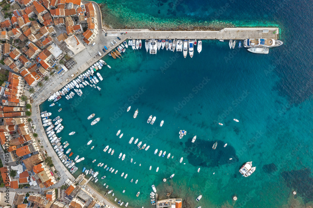 Aerial overhead done shot of Komiza town port on Vis Island in Croatia dusk hour Aerial overhead done shot of Komiza town port on Vis Island in Croatia dusk hour