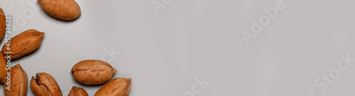 Valokuva Assorted pecan nuts in shell on gray background with copy space