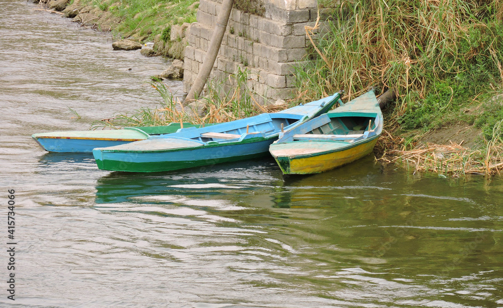 Three colorful rowboats on the bank of the Nile Three colorful rowboats on the bank of the Nile