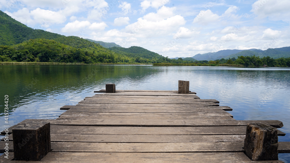 Empty wooden bridge or table top with the lake mountain and sky landscape. Wood floor with lake mountain and sky of nature park background and summer season, product display montage.