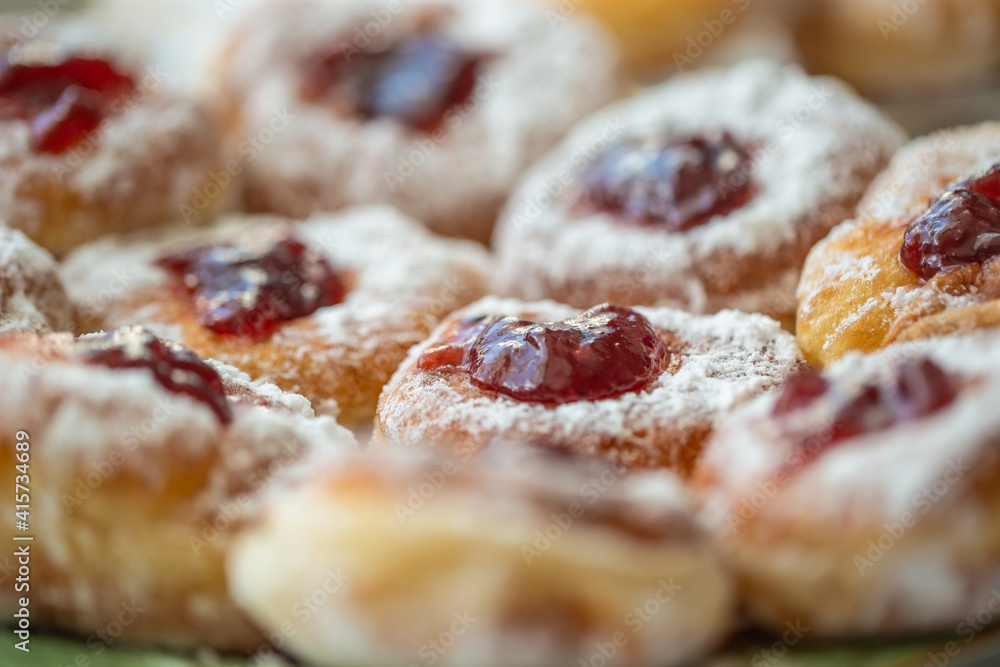 Detail of a plate of donuts filled with jam and coated in sugar